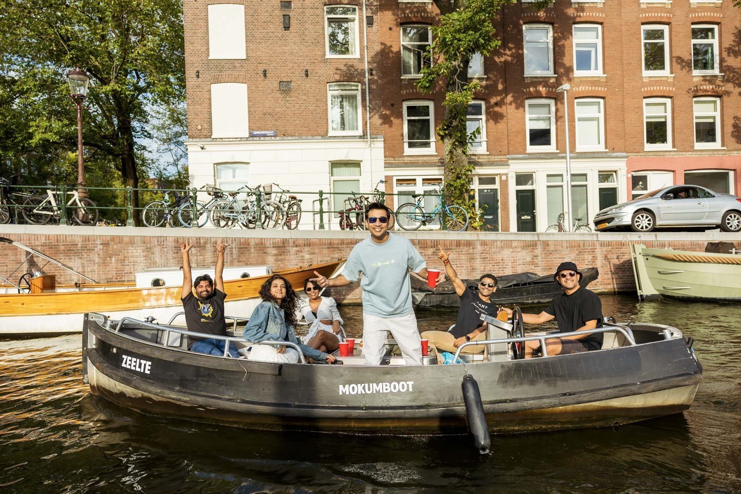Lachende Mokumboot-gasten genieten op de Amstel